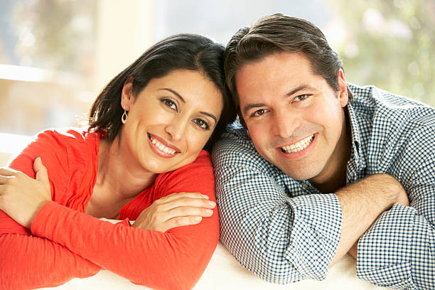 istock Hispanic Couple Relaxing At Home On Sofa 155139279