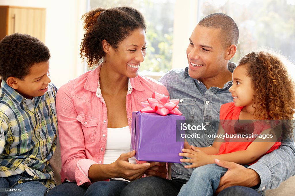 Famiglia dando madre regalo - Foto stock royalty-free di Festa della mamma