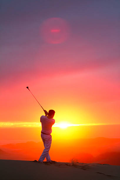 A b&w image of a golfer at the top of his swing.