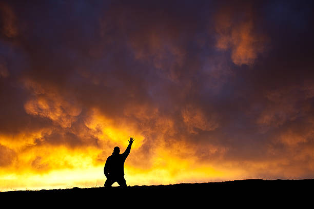 hand to heaven - praying men god kneeling stock-fotos und bilder