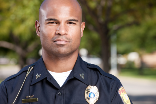 Head and shoulders portrait of a mid-adult african american law enforcement police officer.