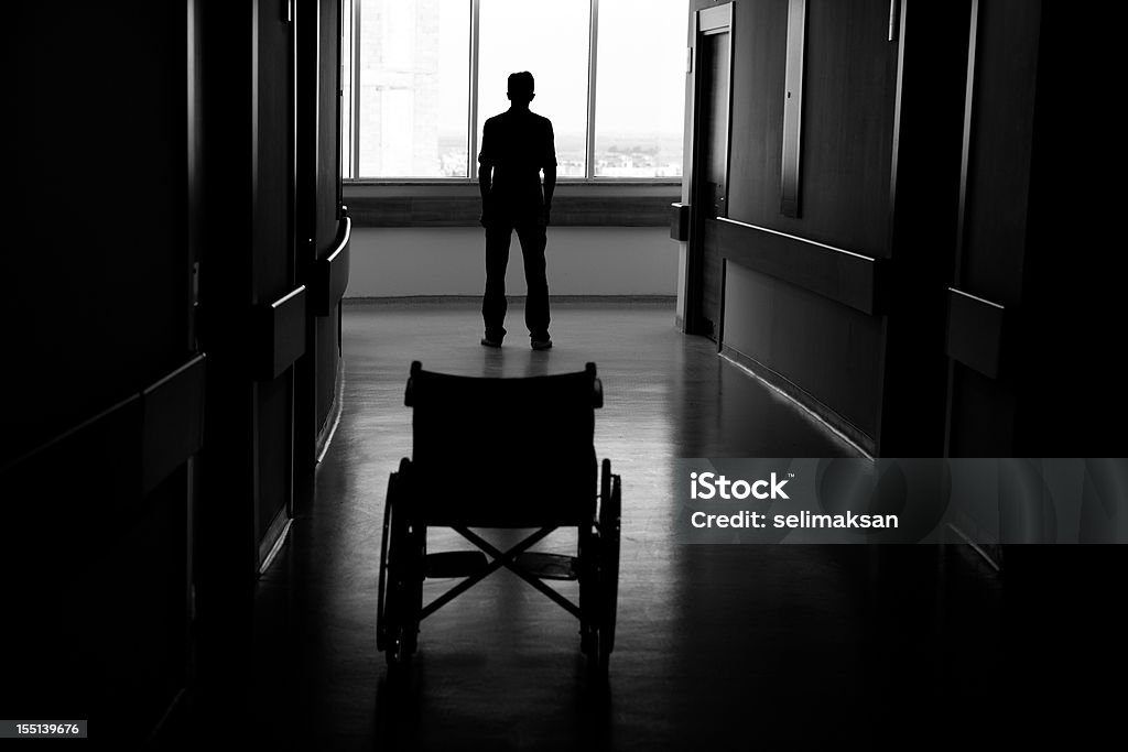 Silueta de hombre salir de la zona de ruedas de hospital - Foto de stock de Silla de ruedas libre de derechos