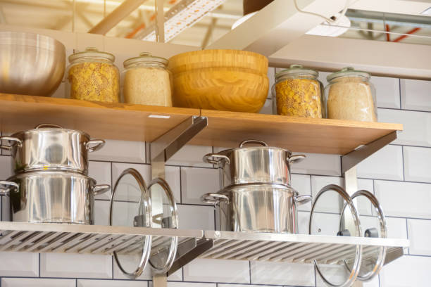 istock Pots and lids with jars for food storage on kitchen shelves. 1551397013