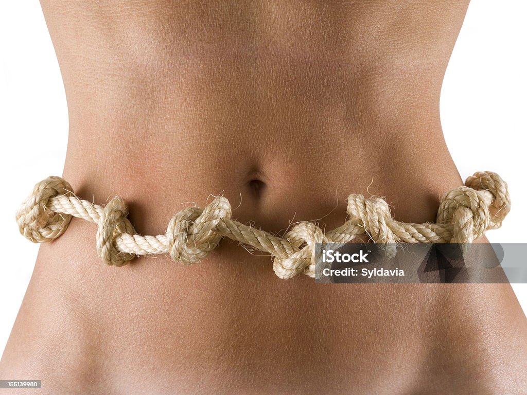 Butterflies in the stomach Woman's abdomen with a knotted rope, around the waist. Constipation Stock Photo