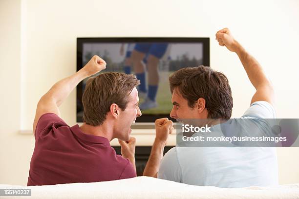 Foto de Dois Homens Assistindo Tv Widescreen Em Casa e mais fotos de stock de Aconchegante - Aconchegante, Adulto, Animar