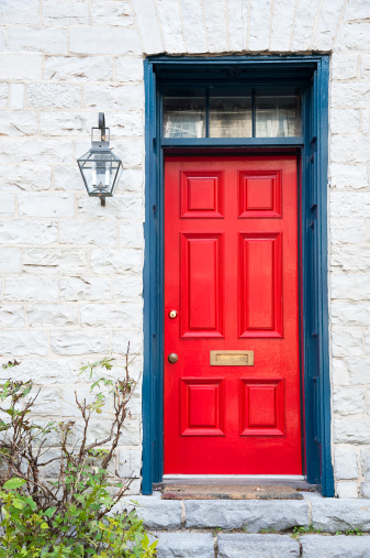 A vibrant red door to an old limestone home in Kingston, Ontario