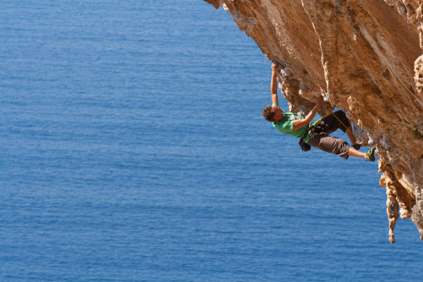 istock Man rock climbing near an ocean 155140296