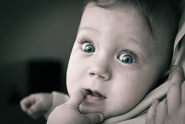 muy curioso bebé con grandes ojos - finger in mouth baby baby boys staring fotografías e imágenes de stock