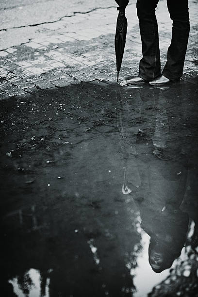 istock Reflection of Attractive Woman in Rain Puddle 155140725
