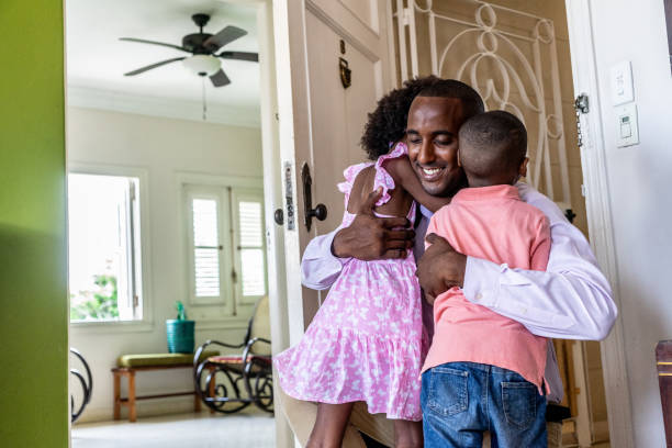 istock Father arriving at home after work and kids embracing him 1551407786