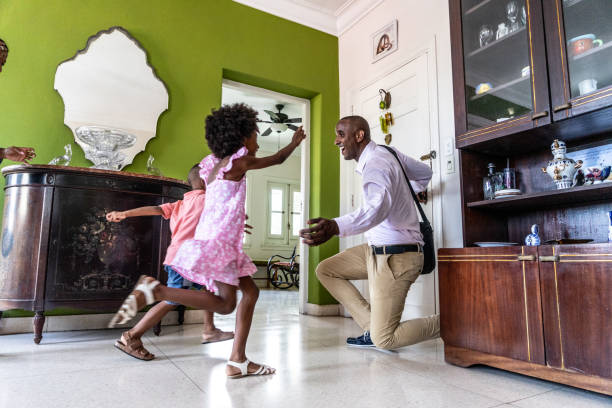 istock Father arriving at home after work and kids embracing him 1551409695