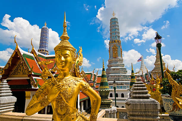 Buddha sculpture in Grand Palace Thailand Wide angled view of Buddha sculpture Kinora or Kinnaree ( mythological creature, half bird, half man ) at Wat Phra Kaeo and Grand Palace in Bangkok, Thailand. Many details of Grand Palace in the background, also visible are beautiful cloudscape with blue sky and cumulus clouds on one sunny day in Bangkok. grand palace bangkok stock pictures, royalty-free photos & images