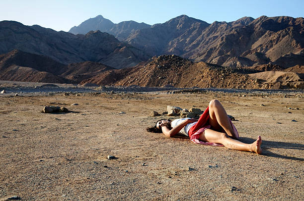 mulher deitada em monoterapia no deserto resistente - garment fragility women skirt imagens e fotografias de stock