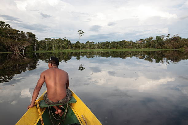Rear view of a man in a boat going down the Amazon River stock photo