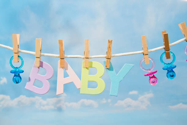 Pacifiers and BABY Letters Hanging On A Clothesline Pacifiers and BABY Letters Hanging On A Clothesline its a girl pacifier clothesline newborn stock pictures, royalty-free photos & images