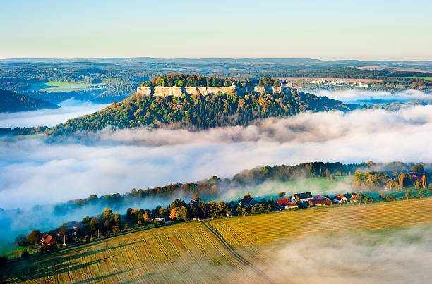 saxon switzerland festung königstein at dawn, famous castle in saxon switzerland elbsandsteingebirge, germany, mist over elbe valley königstein fortress stock pictures, royalty-free photos & images