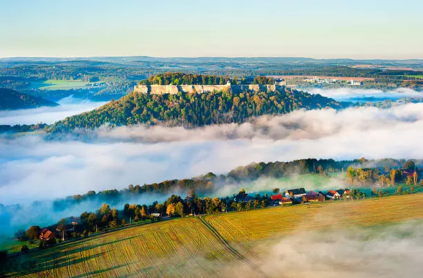 festung königstein at dawn, famous castle in saxon switzerland elbsandsteingebirge, germany, mist over elbe valley