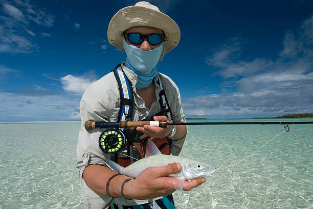 fly fishrman con su pesca - bonefish fotografías e imágenes de stock