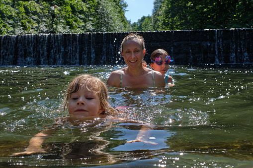 Close up of young family swimming in the  crystal clear river