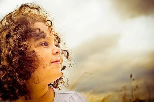 Royalty free stock photo of happy 5 years old girl enjoying day out in the park.