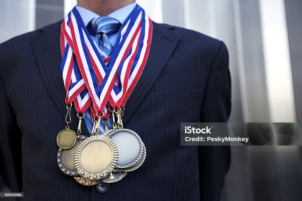 Uomo d'affari in piedi all'aperto arredato con medaglie - Foto stock royalty-free di Grande gruppo di oggetti