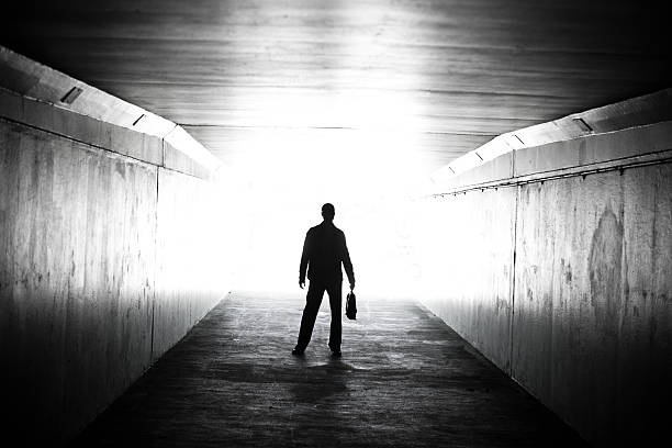istock Lone businessman walking through tunnel with briefcase 155142228