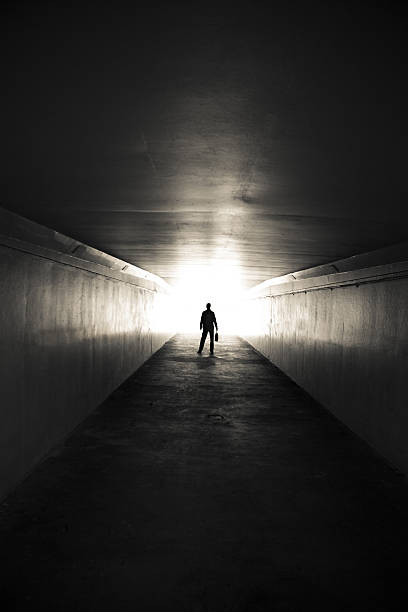 istock Lone businessman walking through tunnel with briefcase 155142229