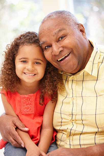 istock An elderly man smiling with his granddaughter on his lap 155142575