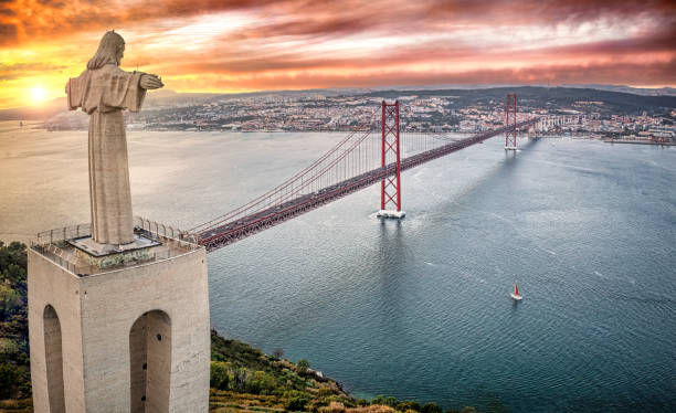 Cristo Rei statue and April 25th Bridge at sunset, Almada, Lisboa Region, Portugal Composition photo of the Cristo Rei statue in front of April 25th Bridge at sunset, Almada, Lisboa Region, Portugal lisbon stock pictures, royalty-free photos & images