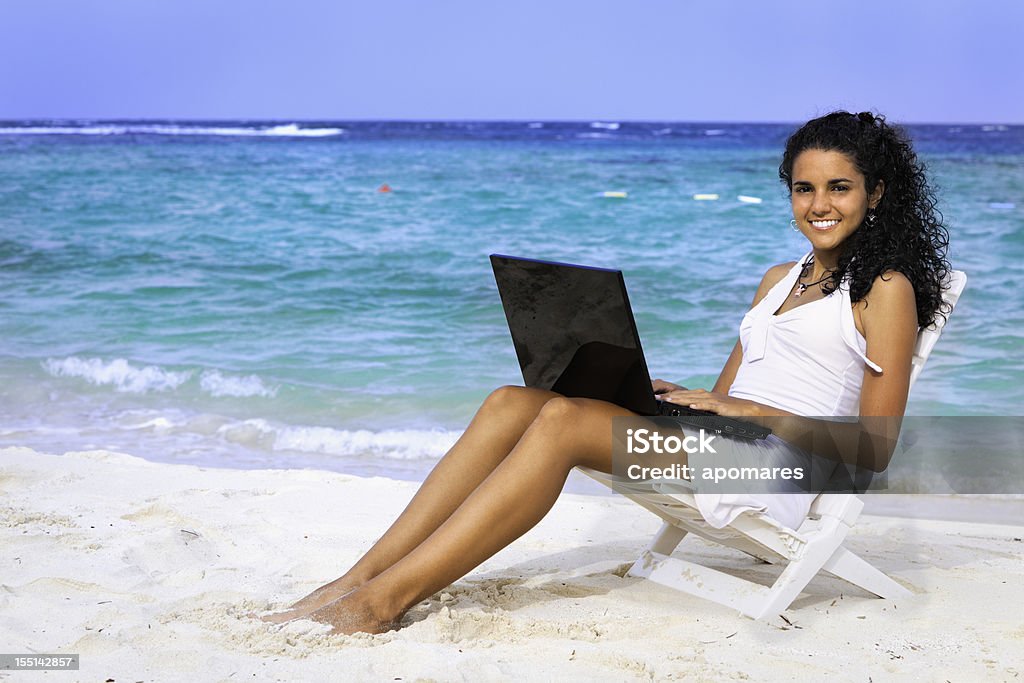 Junge Frau, die arbeitet mit laptop auf einer tropischen türkisfarbenen Strand - Lizenzfrei Strand Stock-Foto