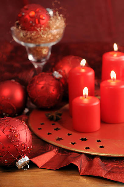 istock four burning Advent candles with Christmas red ornaments 155142860