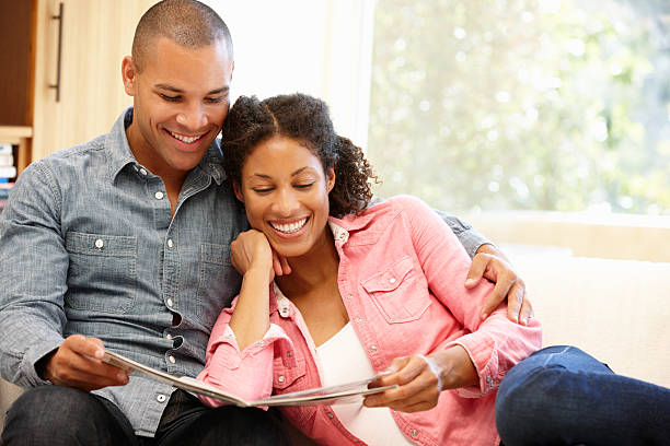 istock Happy couple at home looking at some magazines 155142930