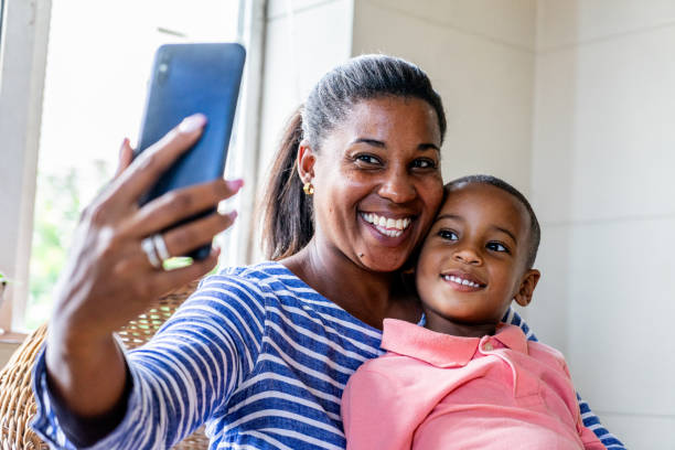 istock Mother and son taking a selfie using mobile phone at home 1551430302