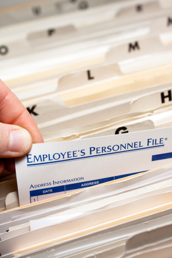Pulling an employee's personnel file; Narrow depth of field.