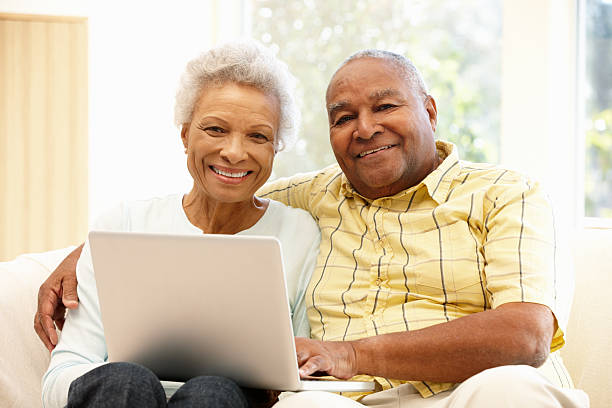 istock Older African American couple using laptop smiling at camera 155143102