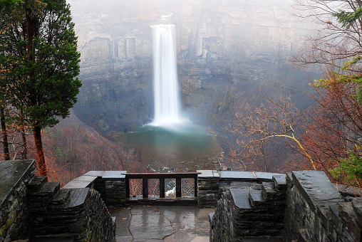 Taughannock Falls cascades through a gorge as seen from on observation deck in a Park on a rainy autumn day