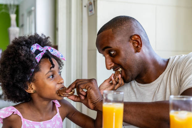 istock Father and daughter feeding during breakfast at home 1551432422