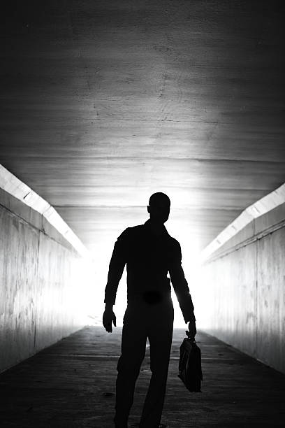 istock Lone businessman walking through tunnel with briefcase 155143406