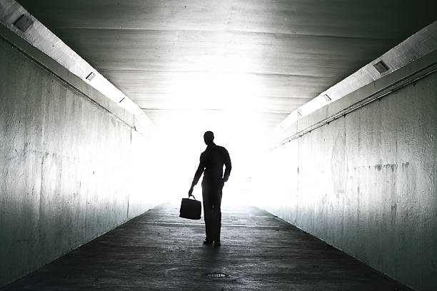 istock Lone businessman walking through tunnel with briefcase 155143411