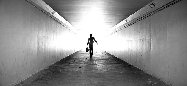 istock Lone businessman walking through tunnel with briefcase 155143418