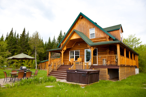 Large wood and stone log home surrounded by a forest