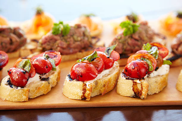 A waiter skillfully carries plates filled with finger food dishes at a festive event, party, or wedding reception.