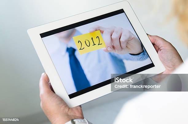 Foto de 2012 Negócios Olhando Um Cartão De Foto Em Tablet Digital e mais fotos de stock de 20-24 Anos