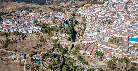 Scenic aerial view of residential areas in small Spanish town of Almansa with dominating medieval walled Castle on hilltop on sunny fall day