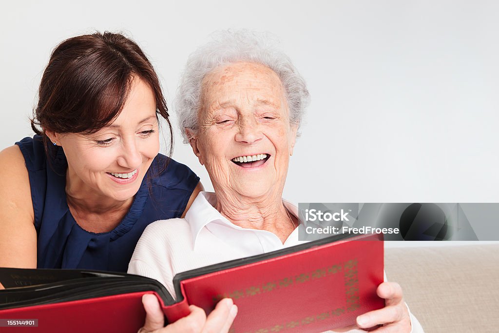 Senior woman and caregiver Senior woman shows pictures to her home caregiver 80-89 Years Stock Photo