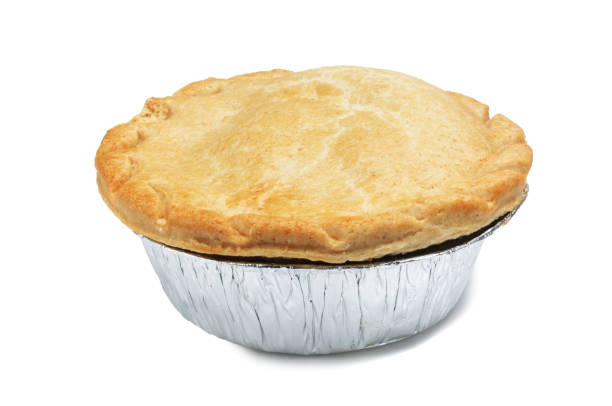 A singular pie in a foil casing Meat pie isolated on white. savoury pie stock pictures, royalty-free photos & images