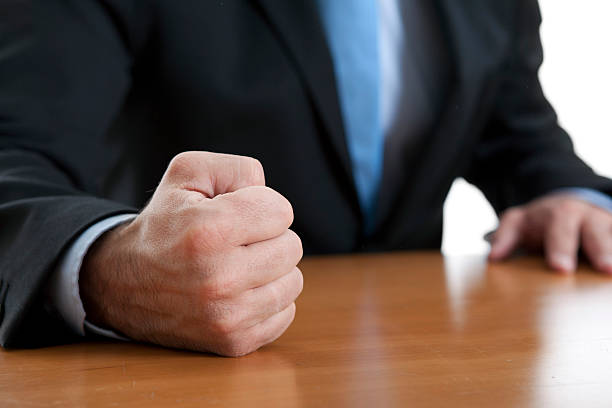 Close-up of a fist of a furious businessman on a table stock photo