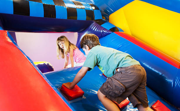 Inflatable Playground Fun Boy and girl  having fun on inflatable playground. mm1 stock pictures, royalty-free photos & images