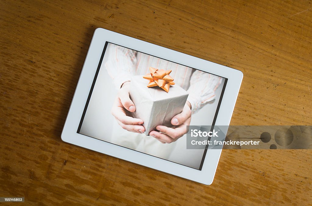Branco contemporâneo tablet digital com presentes de foto na mesa de madeira - Foto de stock de Natal royalty-free