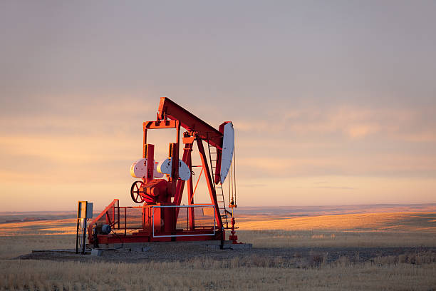 rojo prairie pumpjack en alberta campo de petróleo - okotoks fotografías e imágenes de stock